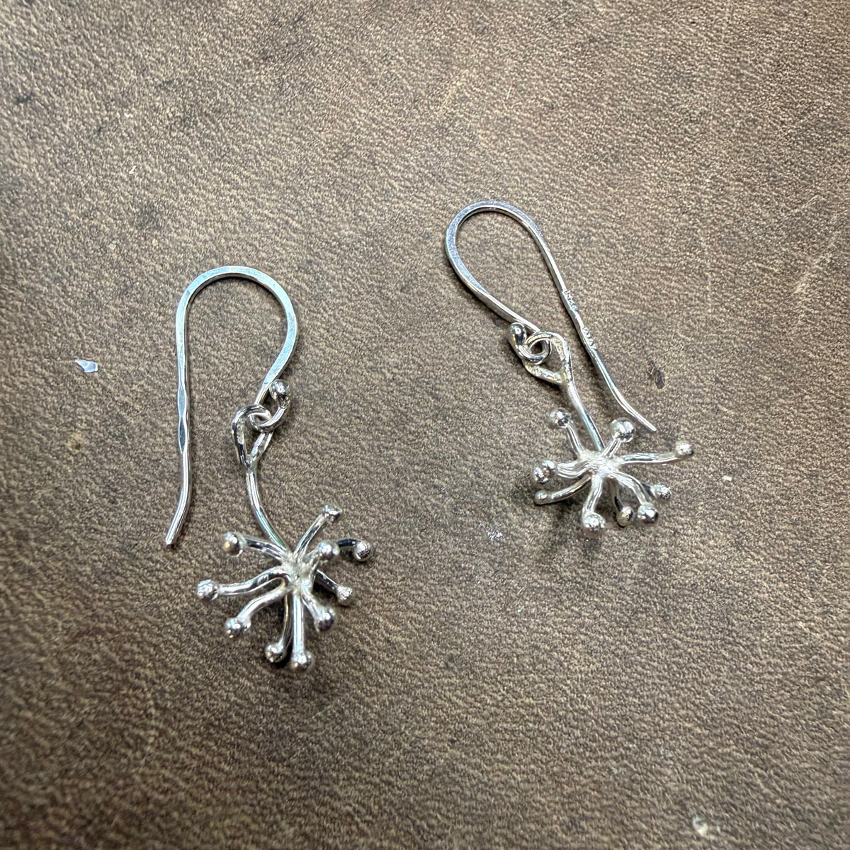 Novemberblomman hängande örhängen i silver, fotograferade framifrån